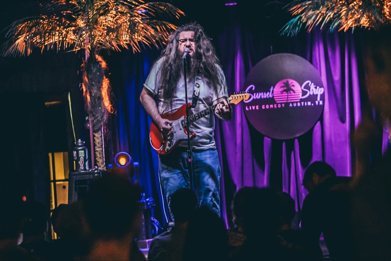 Kelsey Hudgins performing at Sunset Strip beneath warm palm-tree lights